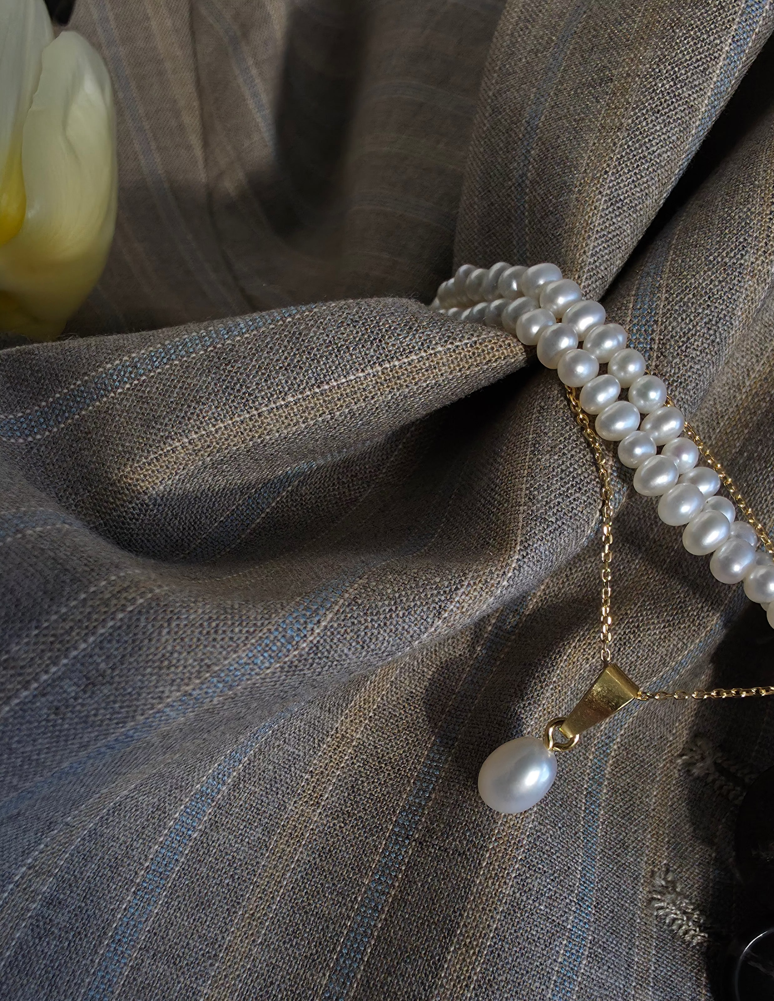Pearl choker on a blazer fabric background