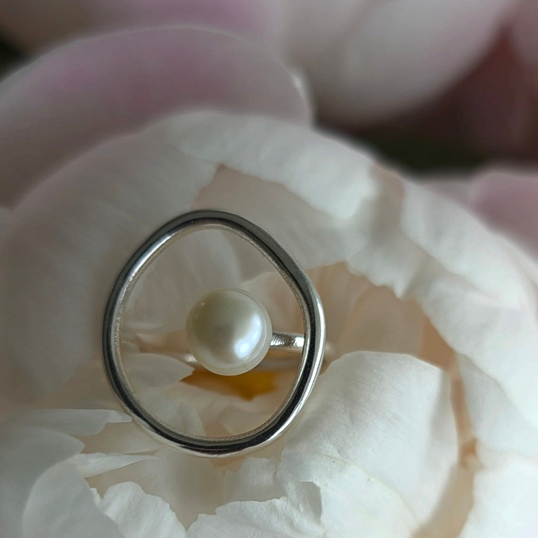 Silver ring with a pearl on white petals