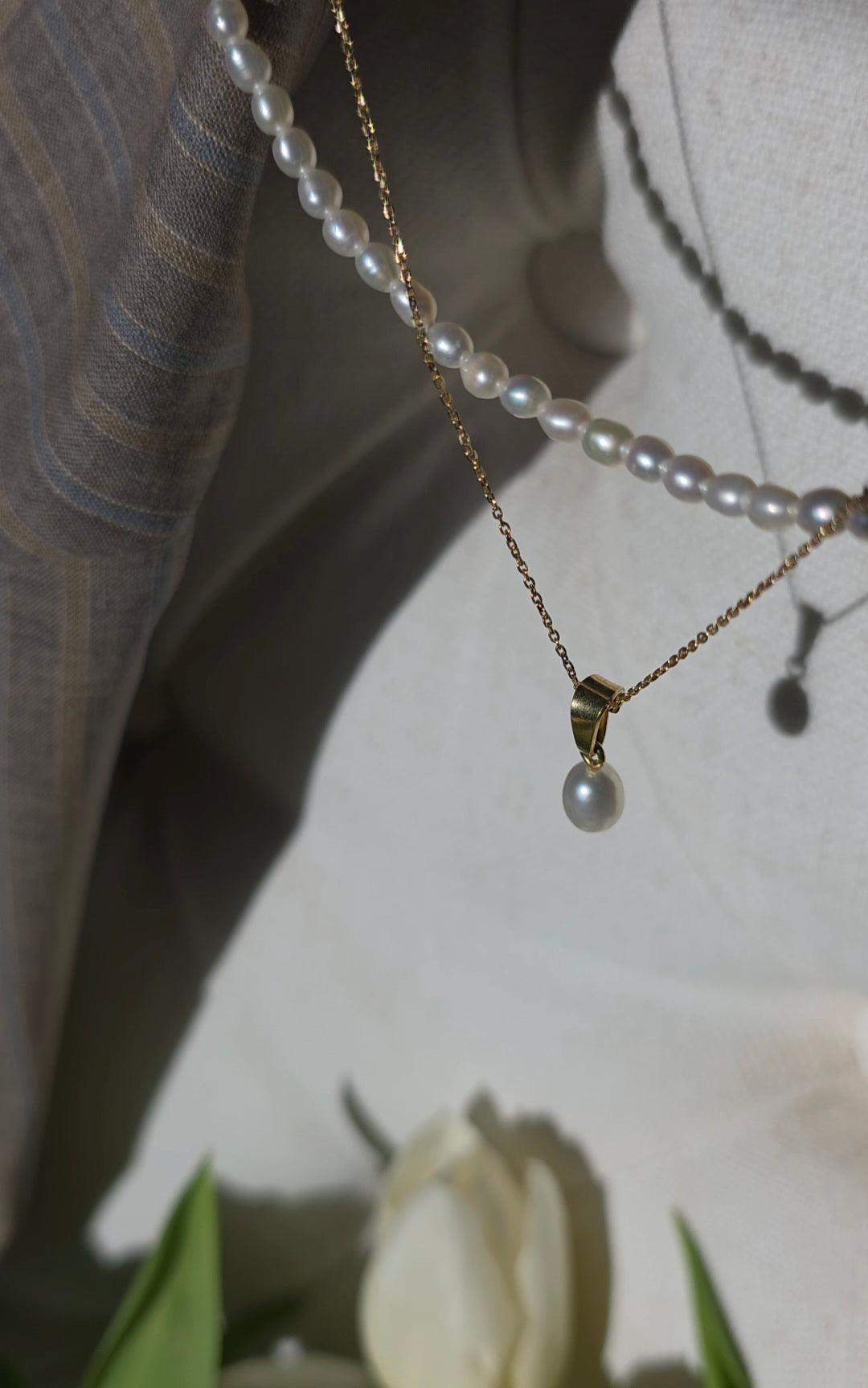 Pearl necklace with a pendant on a neutral background