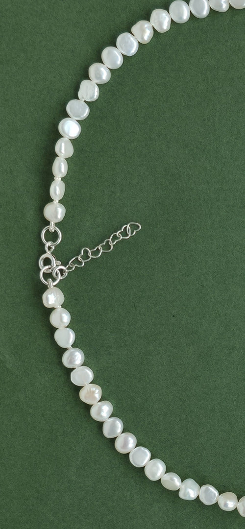 Pearl necklace on a green background