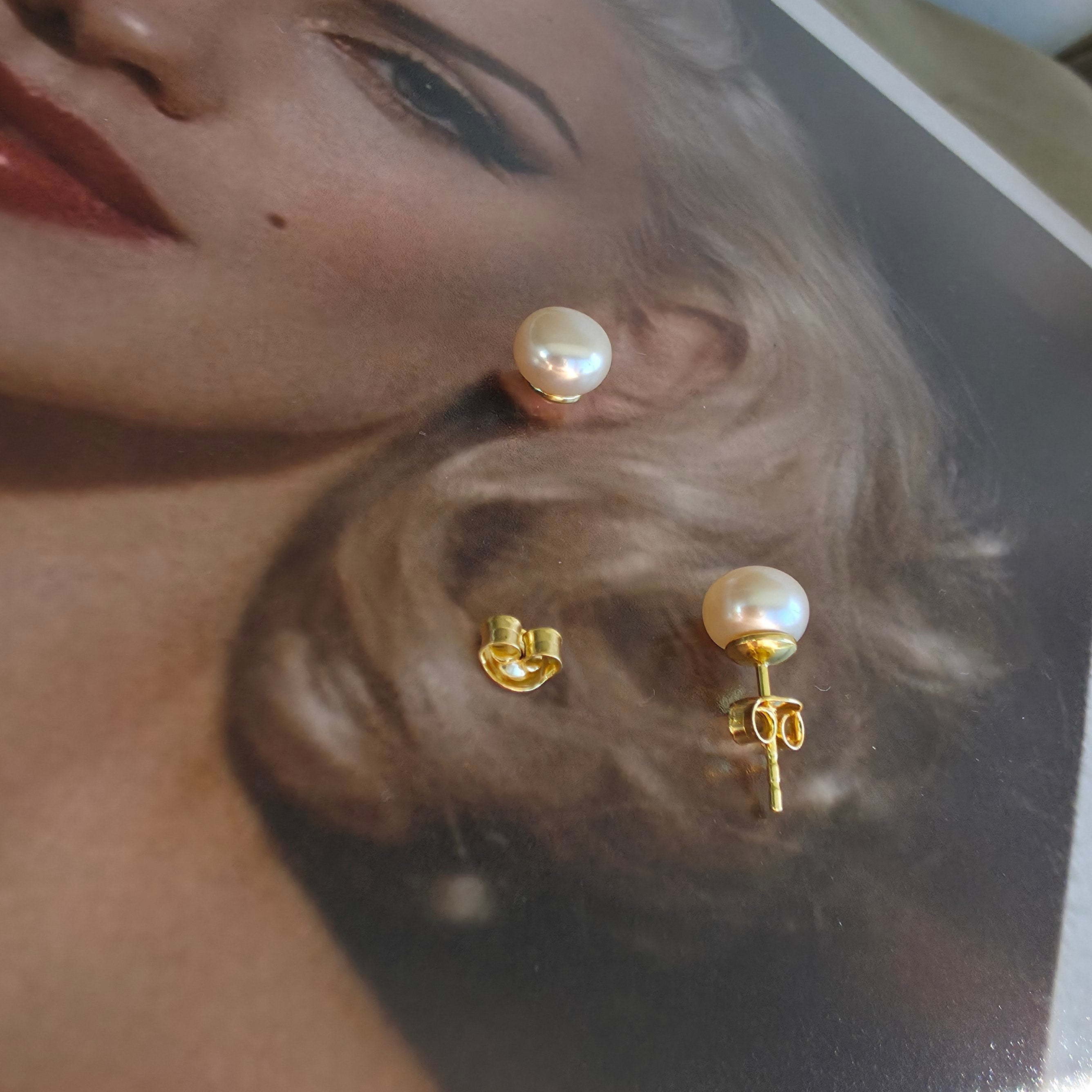 Close-up of pearl earrings on a model with a blurred background