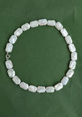 Pearl necklace on a green background