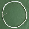 Pearl necklace on a green background