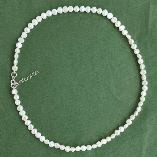 Pearl necklace on a green background