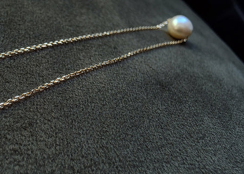 Pearl necklace on a textured gray surface