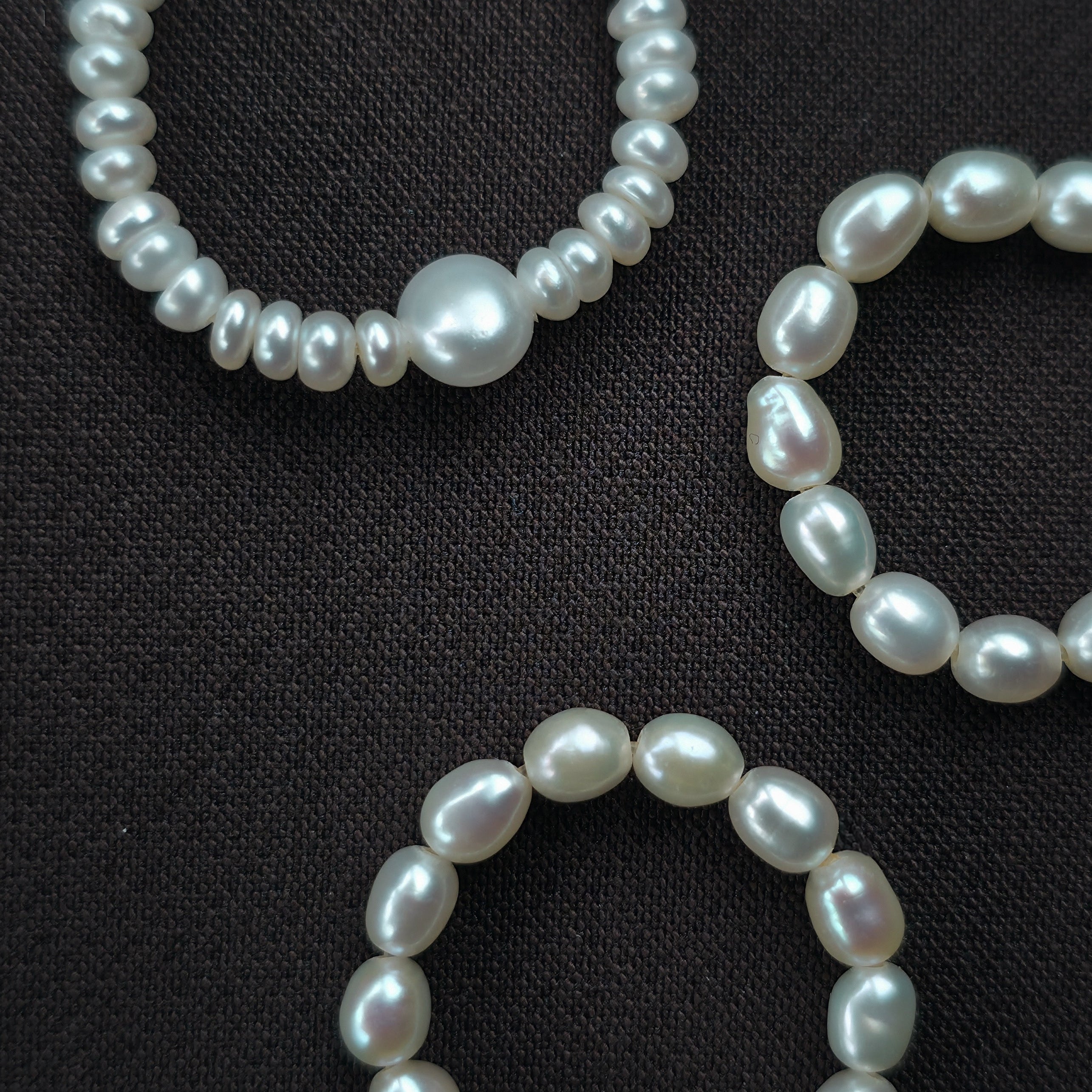 Three pearl rings on a black background. 